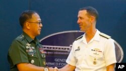 Philippine Armed Forces Chief Gen. Carlito Galvez Jr., left, and Adm. John Richardson, chief of Naval Operations of the U.S. Navy, shake hands prior to a news conference following their meeting at Camp Aguinaldo in suburban Quezon city, northeast of Manila.