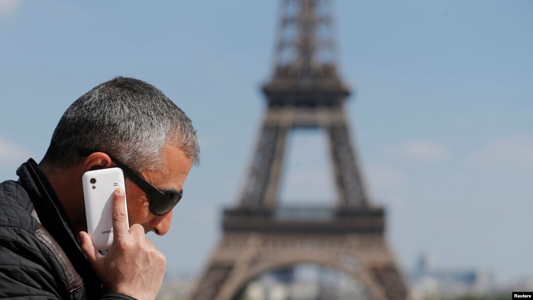 A man makes a phone call using his mobile phone at the Trocadero Square near the Eiffel Tower in Paris, May 16, 2014. 