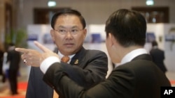 FILE - Cambodian business tycoon Ly Yong Phat, left, waits for Cambodia's Prime Minister Hun Sen to arrive for the Cambodia-China Business and Investment Forum at the outskirt of Phnom Penh, Cambodia, Thursday, Dec. 1, 2016. (AP Photo/Heng Sinith)