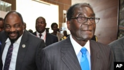 Zimbabwe's President Robert Mugabe, right, arrives for the heads of state meeting of the annual African Union (AU) summit, held at the AU headquarters in Addis Ababa, Ethiopia, Jan. 30, 2015. 