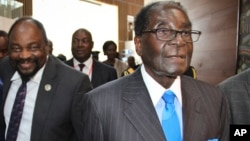 FILE: Zimbabwe's President Robert Mugabe, right, arrives for the heads of state meeting of the annual African Union (AU) summit, held at the AU headquarters in Addis Ababa, Ethiopia, Jan. 30, 2015. 