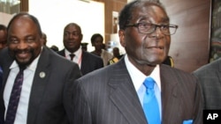 Zimbabwe's President Robert Mugabe, right, arrives for the heads of state meeting of the annual African Union (AU) summit, held at the AU headquarters in Addis Ababa, Ethiopia, Jan. 30, 2015. 
