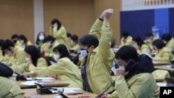 A government official wearing a face mask stretches as he and his colleagues make phone call to members of Shincheonji Church of Jesus to check if they are having symptoms of the COBID-19 illness at Goyang City Hall in Goyang, South Korea, March 3, 2020. 