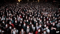 People using face masks attend a music concert in Barcelona, Spain, March 27, 2021.