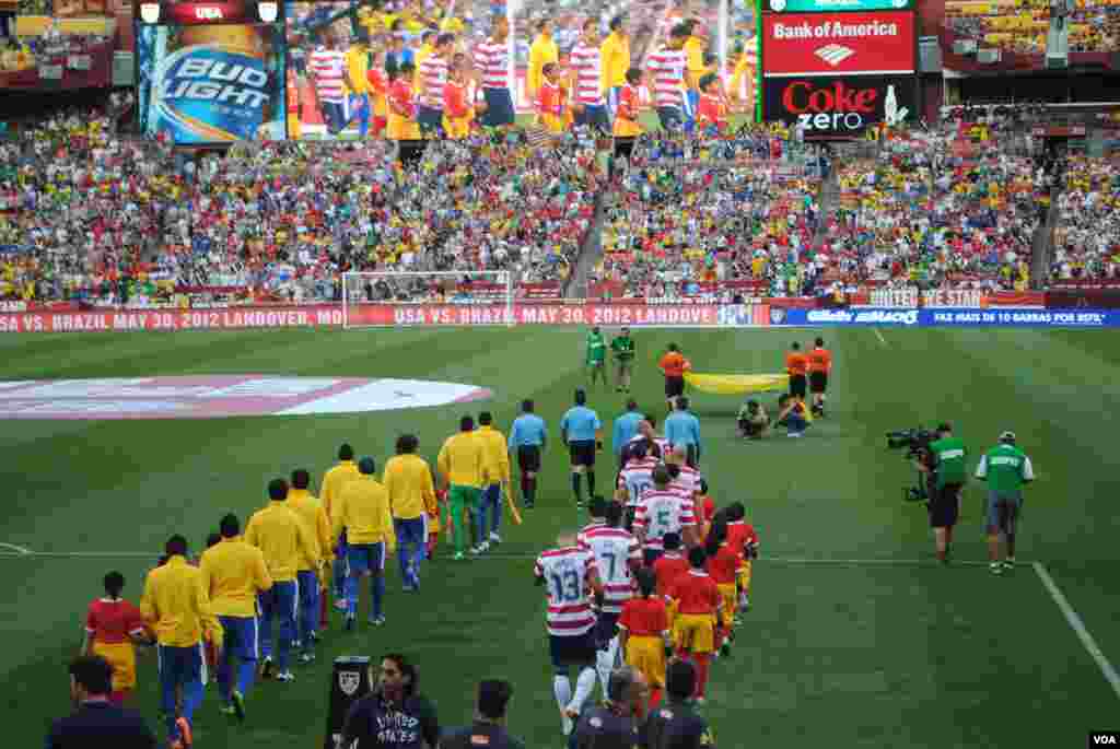 Brasileros y estadounidenses entonan sus himnos momentos antes del encuentro. VOA/M. Lipin