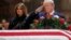 US President Donald J. Trump, with First Lady Melania Trump, salutes the casket containing the body of former US President George H.W. Bush in the Rotunda of the US Capitol in Washington, DC, December 3, 2018. 