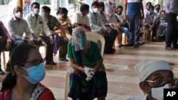 People wait to receive a COVID-19 vaccine outside an inoculation site in Mumbai, India, May 13, 2021.