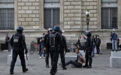 Police detain a protester during a demonstration in Paris, France, July 31, 2021. Demonstrators gathered in several cities to protest against the COVID-19 pass, which grants vaccinated individuals greater ease of access to venues.