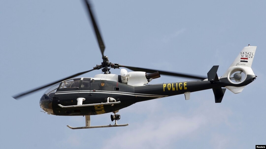 A police helicopter flies as police officers boost security around a new memorial in the center of Tahrir Square in Cairo, Nov. 18, 2013.