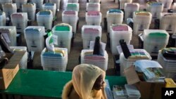 FILE - A Kenyan election volunteer walks past ballot boxes and electoral material to be distributed to various polling stations in Nairobi, Kenya, Aug. 7, 2017. Kenyans went to the polls Aug. 8 but the vote results were annulled by the country's Supreme Court.