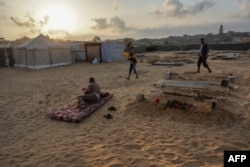 Displaced Palestinians from the eastern part of Khan Younis set up a temporary camp on the grounds of a cemetery in the western part of the city in the southern Gaza Strip on July 26, 2024.