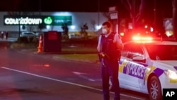 Police stand outside the site of a knife attack at a supermarket in Auckland, New Zealand, Sept. 3, 2021.