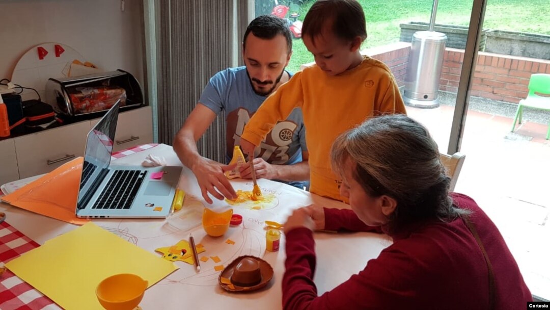 Benjamín recibe una clase virtual, mientras es ayudado por su padres y su abuela.