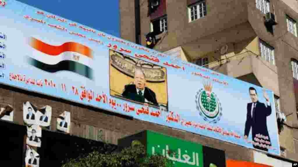 A youthful-looking portrait of the now 82-year old President Mubarak, right, emblazons a banner in support for a candidate.