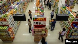 FILE - People shop in a supermarket inside a department store in Bangkok.