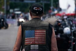 A man with a long beard wears a vest with the US flag on the back as he walks on Main Street during the 80th Annual Sturgis Motorcycle Rally on Aug. 8, 2020 in Sturgis, South Dakota. Masks are not required at the event.