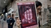FILE - A protester holds a picture of imprisoned and prominent Chinese human rights lawyer Wang Quanzhang during a protest outside the Chinese liaison office in Hong Kong, July 13, 2018.