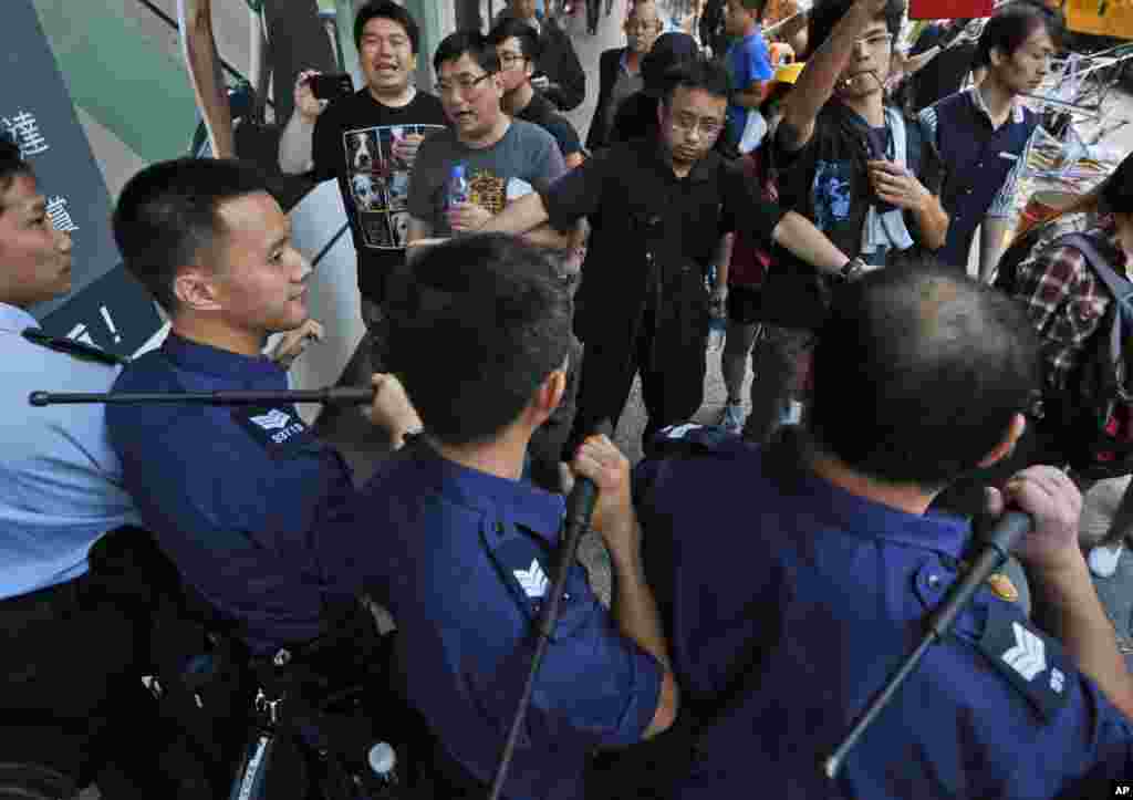 Riot police officers stop the pro-democracy protesters from reoccupying the area in the Mong Kok district of Hong Kong, early Friday, Oct. 17, 2014.