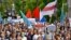 People carrying a poster reading "Long Live Belarus", and an old Belarusian national flag, march during an unsanctioned protest in support of Sergei Furgal, the governor of the Khabarovsk region, Russia, Aug. 15, 2020. 