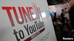 Les visiteurs passent devant un stand YouTube pendant le marché international de l'édition de musique d'enregistrement et de la musique vidéo (MIDEM) à Cannes, France, le 27 janvier 2013.