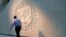 FILE — A man walks past the International Monetary Fund (IMF) logo at its headquarters in Washington, on May 10, 2018.
