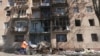 FILE - A woman walks past a building damaged by Ukrainian strikes in Kursk following Ukraine's offensive into Russia's western Kursk region, Aug. 16, 2024. Since Kyiv launched its cross-border assault into the Kursk region in August 2024, Moscow has been pushing back hard.