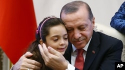 Presiden Turki Recep Tayyip Erdogan memeluk Bana Al-Abed, (7 tahun), di Istana Presiden di Ankara, Turki, Selasa (21/12).