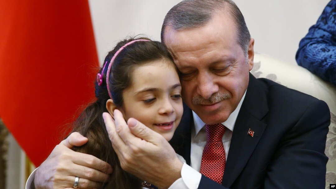 Turkey's President Recep Tayyip Erdogan, embraces Bana Al-Abed, 7, from Aleppo, Syria, at his Presidential Palace in Ankara, Dec. 21, 2016.