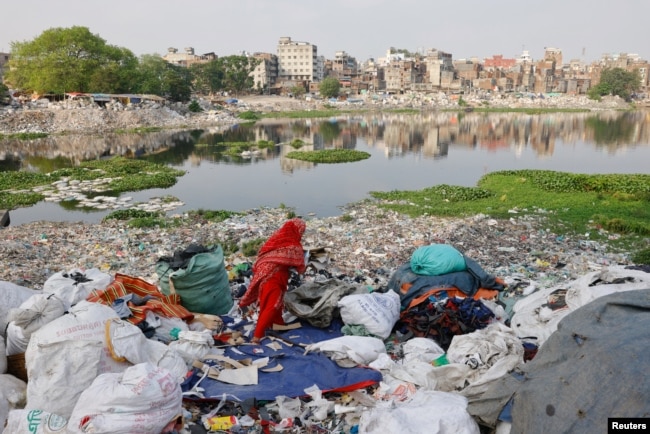 Plastic waste floats in the Buriganga river while a woman sorts it for recycling in Dhaka, Bangladesh, April 21, 2024. (REUTERS/Mohammad Ponir Hossain/File Photo)