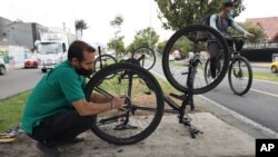 El venezolano Michael Ostis, de 33 años, repara una bicicleta, en Bogotá, el 9 de febrero de 2021.