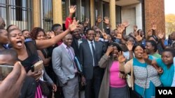 Friends and relatives of 27 people arrested during last week’s opposition protests celebrate outside the Harare Magistrates Court after their loved ones had been granted bail, in Harare, Zimbabwe, Aug. 7, 2018. (C. Mavhunga/VOA)