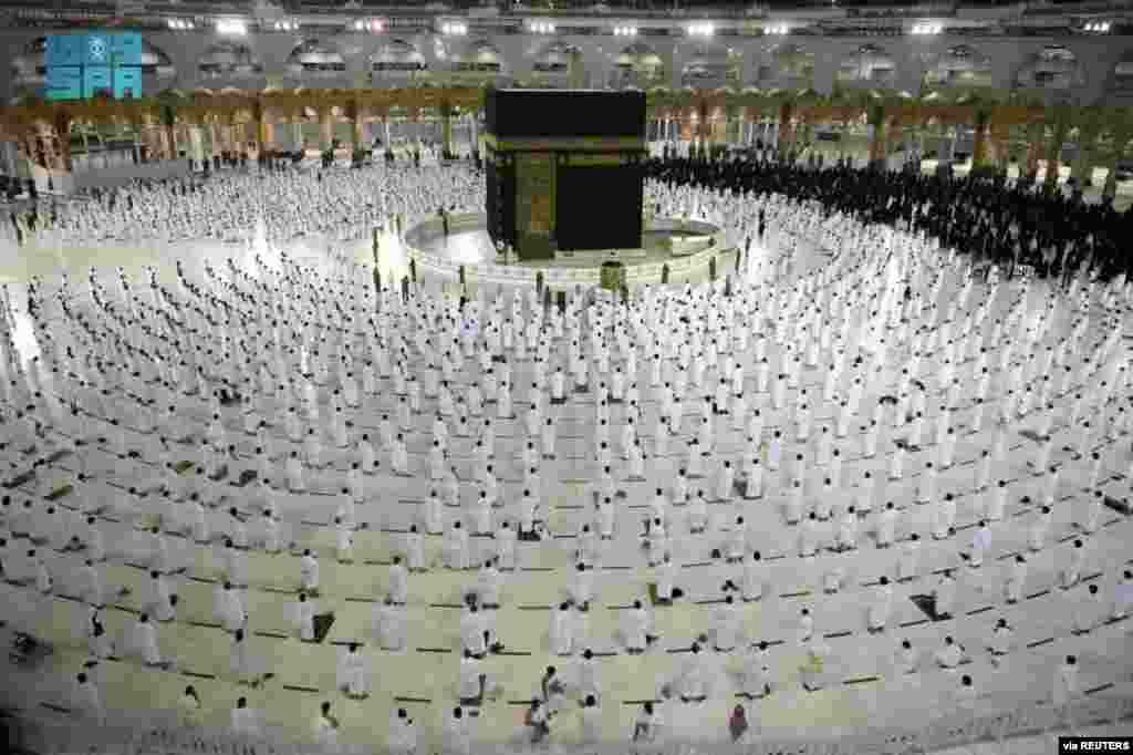 Muslims, maintaining social distancing, perform late night prayers on the night of 27th Ramadan in the Grand Mosque during the holy month of Ramadan, in the holy city of Mecca, Saudi Arabia. (Credit: Saudi Press Agency)