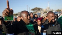 Mineworkers dance as they gather for check-ins near Lonmin's Marikana platinum mine before returning to work, June 25, 2014. 