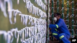 Silva Cossa, the caretaker, ties ribbons onto the fence to represent each South African who has died from COVID-19, at St James Presbyterian church in Johannesburg, July 29, 2020.