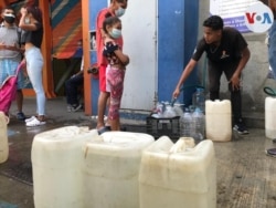 Vecinos de una urbanización del municipio Chacao, al este de Caracas, aguardan en un punto de suministro de agua para llenar envases. Desde hace 21 días no reciben agua a través de tuberías. Agosto, 2021. Foto: Carolina Alcalde - VOA.