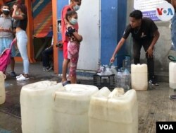 Vecinos de una urbanización del municipio Chacao, al este de Caracas, aguardan en un punto de suministro de agua para llenar envases. Desde hace 21 días no reciben agua a través de tuberías. Agosto, 2021. Foto: Carolina Alcalde - VOA.