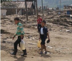 북한 함경북도 무산군 수재민 아동들이 물을 길어 나르고 있다. 사진출처: 유엔아동기금 UNICEF 함경북도 수해 지원 상황 보고서.