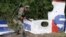 A pro-Russian rebel looks at pieces from the wreckage of the Malaysia Airlines Flight 17 near the village of Rozsypne, eastern Ukraine, Sept. 9, 2014. 