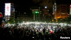 Pro-democracy protesters switch on their mobile phones during a campaign to kick off the Occupy Central civil disobedience event in front of the financial Central district in Hong Kong, Aug. 31, 2014.