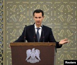 Syria's President Bashar al-Assad speaks during a meeting with heads of local councils, in Damascus, Syria, Feb. 17, 2019.
