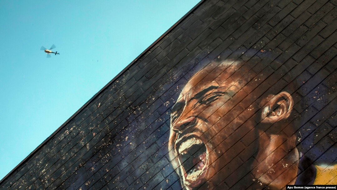 Sebuah helikopter terbang di atas mural Kobe Bryant di pusat kota Los Angeles, 26 Januari 2020. Sembilan orang tewas dalam kecelakaan helikopter yang merenggut nyawa bintang NBA Kobe Bryant dan putrinya yang berusia 13 tahun. (Foto: AFP/Apu Gomes)