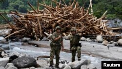 Des débris balayés par de fortes pluies se sont empilés. Des soldats japonais de la force d'autodéfense sont présents dans le village de Toho, dans la préfecture de Fukuoka, au Japon, le 8 juillet 2017.