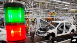 FILE - A worker assembles a car at a factory for Chinese automaker BAIC Motor in Beijing.