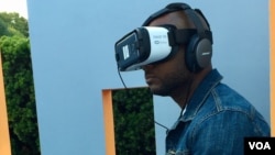 Duane Rollins of Washington, D.C., tries an exhibit that simulates solitary confinement. He said "It takes away your humanity," he said. (M. Salinas/VOA)