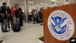 File - Airline passengers wait go through the Transportation Security Administration security checkpoint at Hartsfield-Jackson Atlanta International Airport.