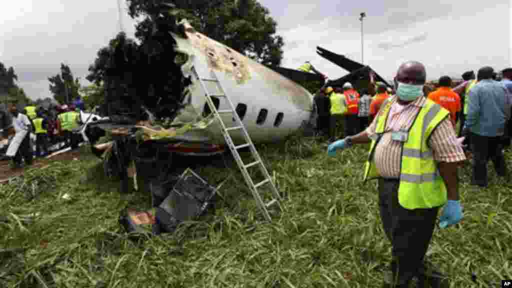 Rescue workers inspect the wreckage of a charter passenger jet which crashed soon after take off from Lagos airport.