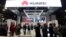 FILE - Attendees pass by a Huawei booth during the 2019 CES in Las Vegas, Nevada, Jan. 9, 2019. 