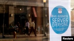 A sign reading "This business serves everyone" is displayed in the window of Bernadette's Barbershop in Lafayette, Indiana, in the wake of the passage of the state's Religious Freedom Restoration Act, March 31, 2015.