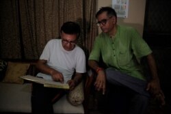 Kashmiri Hindu man Vijay Kaul, right, sits with his neighbor Ashok Bhatt, at his residence in New Delhi, Aug. 21, 2019, as he recites lines from a poem he wrote in 2015 when Kaul visited his ancestral home near Srinagar.