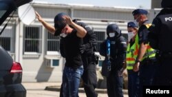 FILE - Austrian and Hungarian police officers attend an exercise to prevent migrants from crossing the Austrian border from Hungary in Nickelsdorf, Austria, July 2, 2020. 